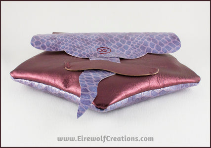 Handmade leather belt pouches in a medieval style with a scaled dragon skin texture, in purple or silver colors. By Erin Metcalf of Eirewolf Creations.