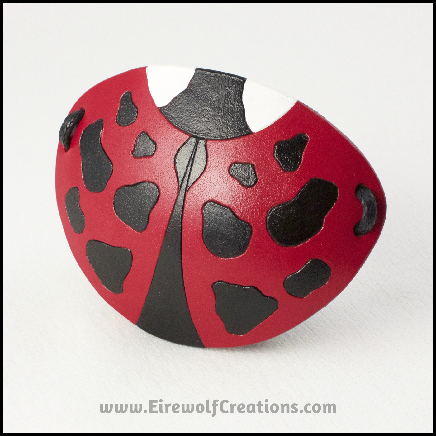 A cute handmade leather Ladybug eye patch, carved and painted red, black, and white. By Erin Metcalf of Eirewolf Creations.