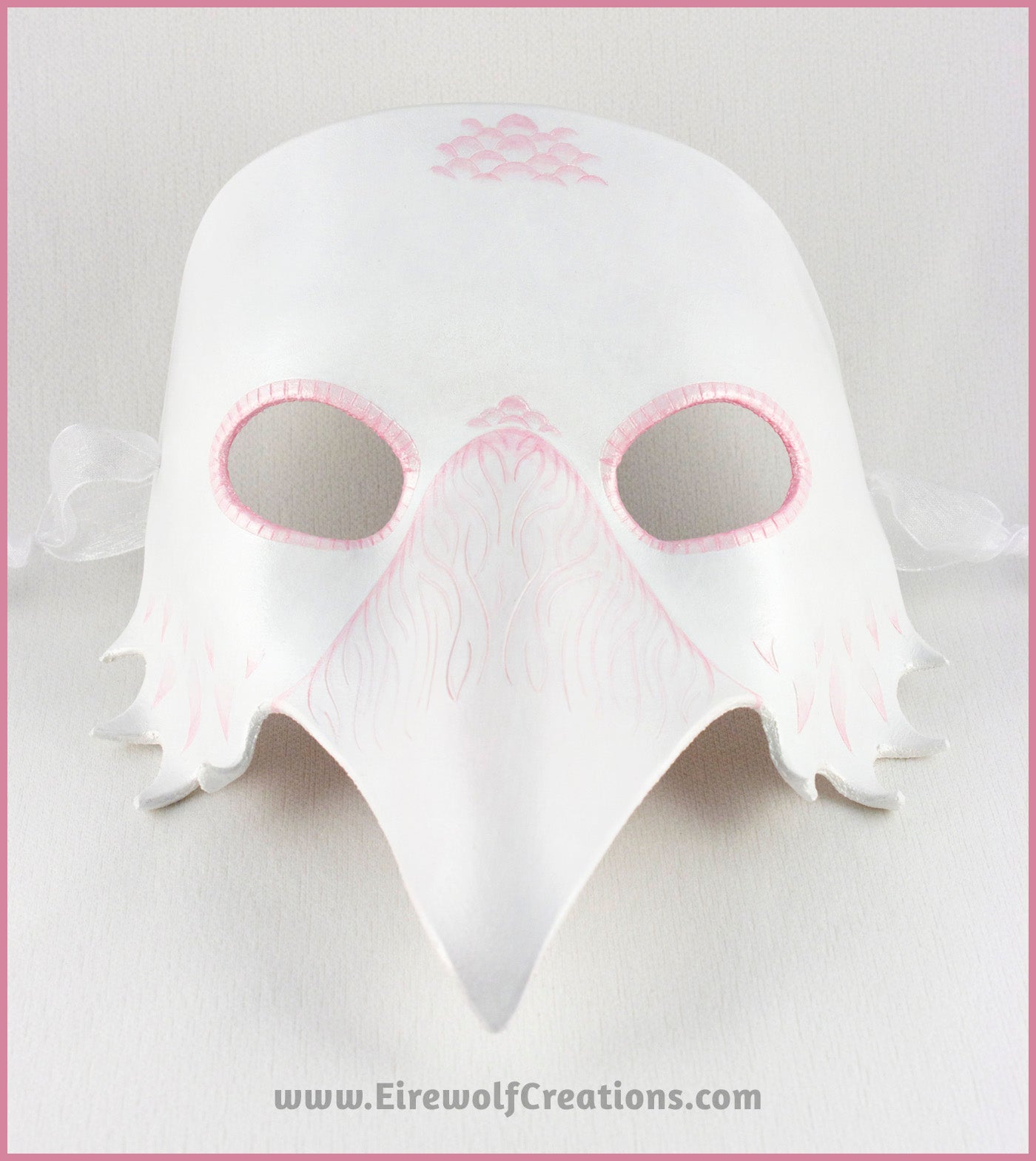 A handmade leather Albino Raven or White Crow mask for a masquerade costume, with carved and handpainted pale pink feather details. By Erin Metcalf of Eirewolf Creations.