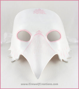 A handmade leather Albino Raven or White Crow mask for a masquerade costume, with carved and handpainted pale pink feather details. By Erin Metcalf of Eirewolf Creations.