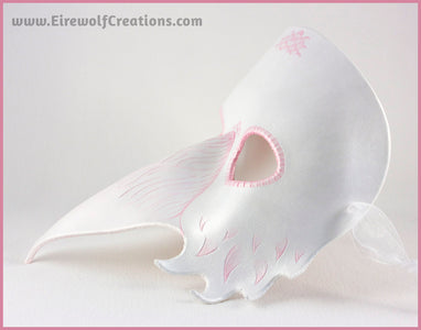 A handmade leather Albino Raven or White Crow mask for a masquerade costume, with carved and handpainted pale pink feather details. By Erin Metcalf of Eirewolf Creations.