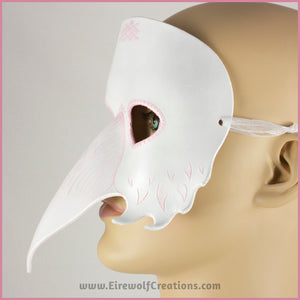 A handmade leather Albino Raven or White Crow mask for a masquerade costume, with carved and handpainted pale pink feather details. By Erin Metcalf of Eirewolf Creations.