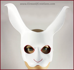 A handmade leather White Rabbit mask for a masquerade or Alice in Wonderland costume, painted white with red details around the eyes and nose. By Erin Metcalf of Eirewolf Creations.