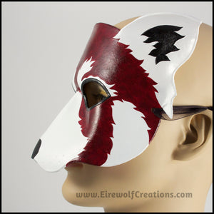 A handmade leather Red Panda masquerade mask with bold facial markings carved and painted on the leather. By Erin Metcalf of Eirewolf Creations.