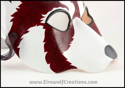 A handmade leather Red Panda masquerade mask with bold facial markings carved and painted on the leather. By Erin Metcalf of Eirewolf Creations.