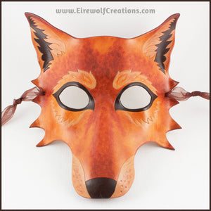 A handmade leather Wolf masquerade mask in rich tawny brown colors, with carved and painted fur details. By Erin Metcalf of Eirewolf Creations.