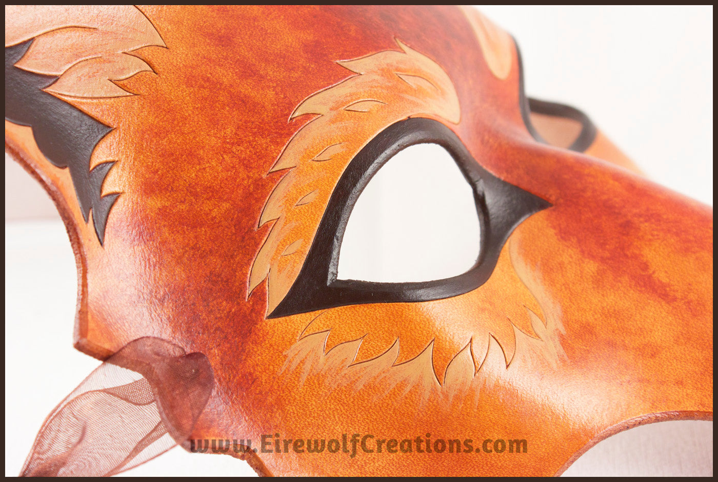 Detail of a handmade leather Wolf masquerade mask in rich tawny brown colors, with carved and painted fur details. By Erin Metcalf of Eirewolf Creations.